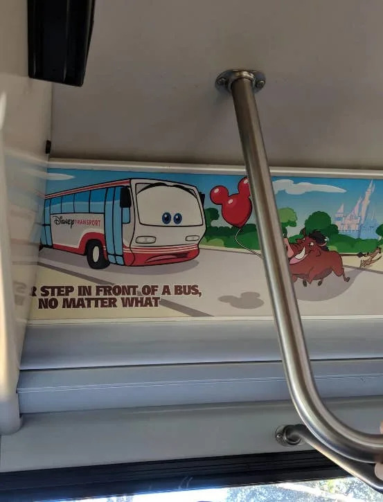 Autobús de dibujos animados con los ojos puestos en un anuncio de Disney Transport, junto a Timon y Pumba de El rey león. Aviso: "Nunca pises delante de un autobús, pase lo que pase" se corta y lee "Pasa delante de un autobús, pase lo que pase"