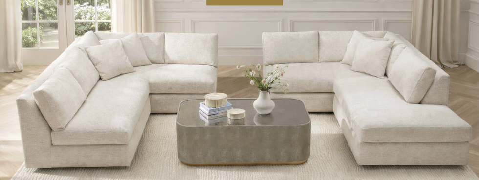 Disposición de asientos en la sala de estar con un sofá seccional moderno y una mesa de café. Disposición de asientos en la sala de estar con un sofá seccional moderno y una mesa de café.