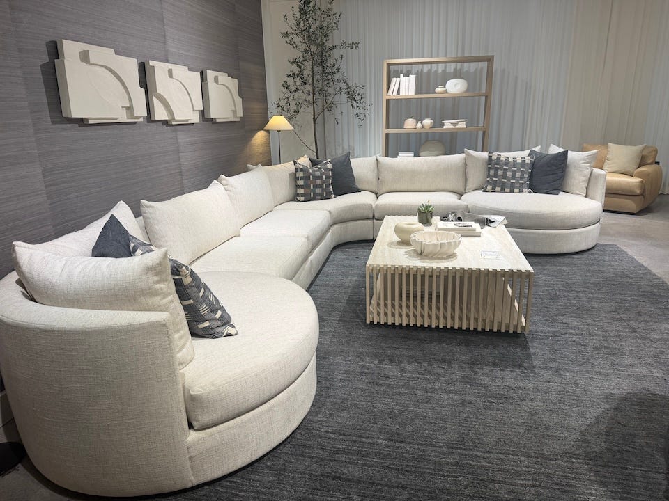 Configuración moderna de la sala de estar con un sofá curvado, una mesa de café y elementos decorativos. Configuración moderna de la sala de estar con un sofá curvado, una mesa de café y elementos decorativos.