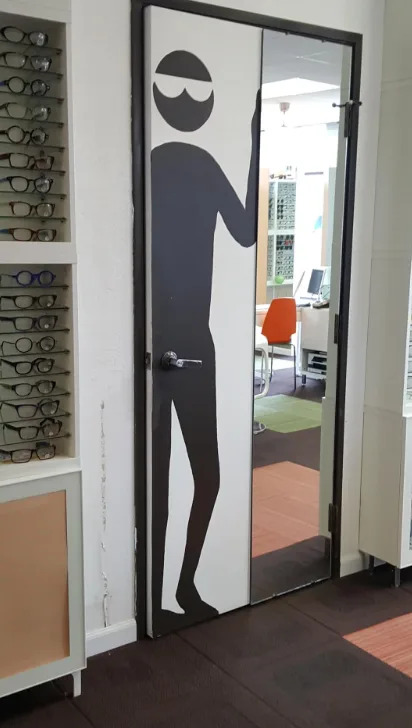 lleva con una silueta juguetona de una persona con gafas de sol. El pomo de la puerta está en la entrepierna