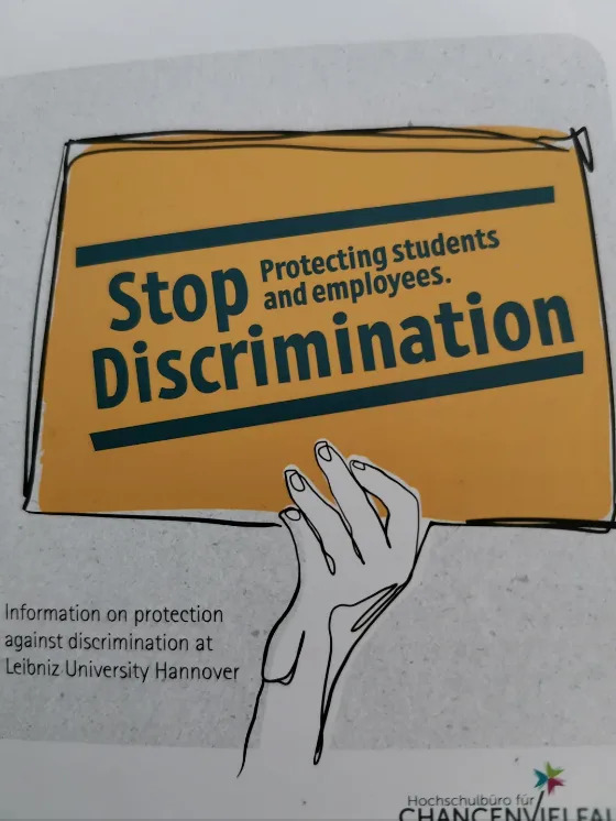 El signo dice: "Detiene la discriminación. Protección de estudiantes y empleados." Sin embargo, de la forma en que está ordenado, parece que se lee "dejar de proteger a estudiantes y empleados. Discriminación"