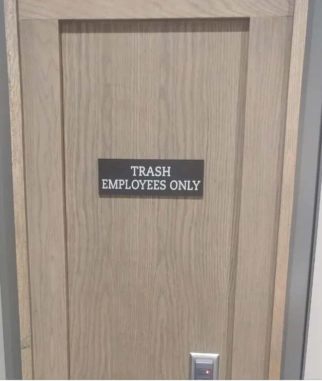 El cartel de una puerta de madera dice: "SOLO PARA EMPLEADOS DE LA BOLSA"