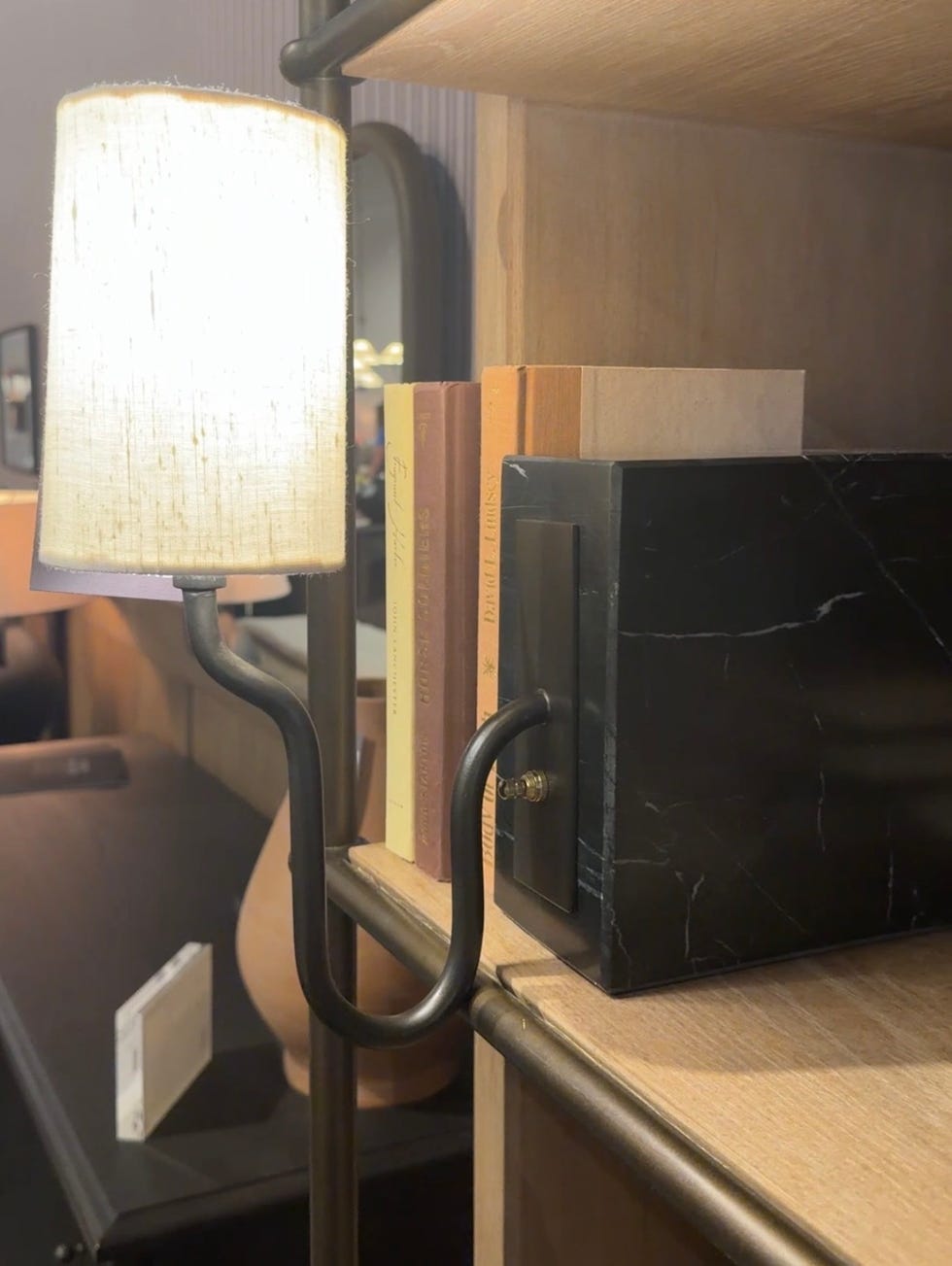 Lámpara junto a un estante con libros y una caja decorativa. Lámpara junto a un estante con libros y una caja decorativa.